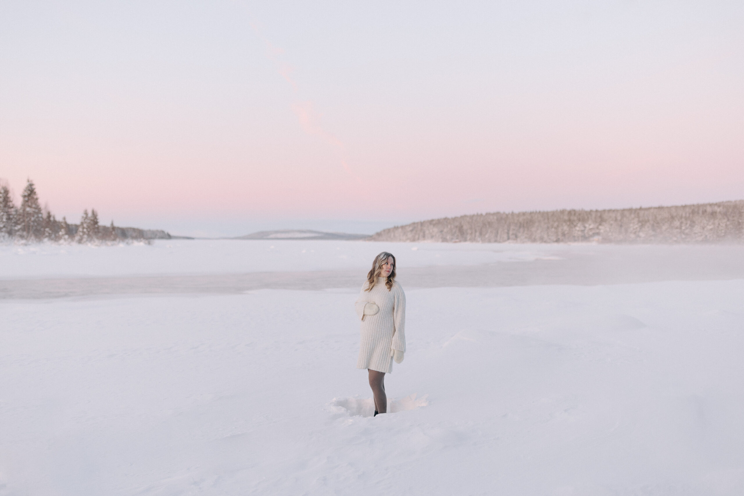 Gravidfotografering i Kiruna en decemberdag med snö, krispiga träd och rosa himmel.